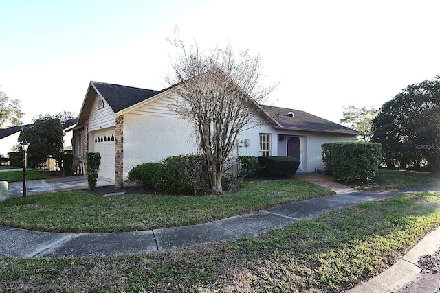 view of front of house featuring a garage, driveway, a front lawn, and stucco siding