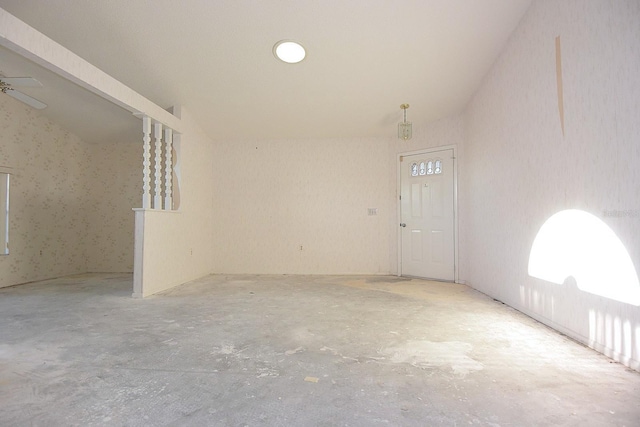 spare room with ceiling fan and unfinished concrete flooring