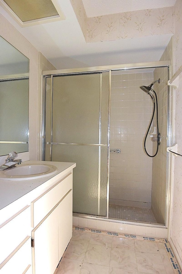 bathroom featuring a stall shower, marble finish floor, and vanity