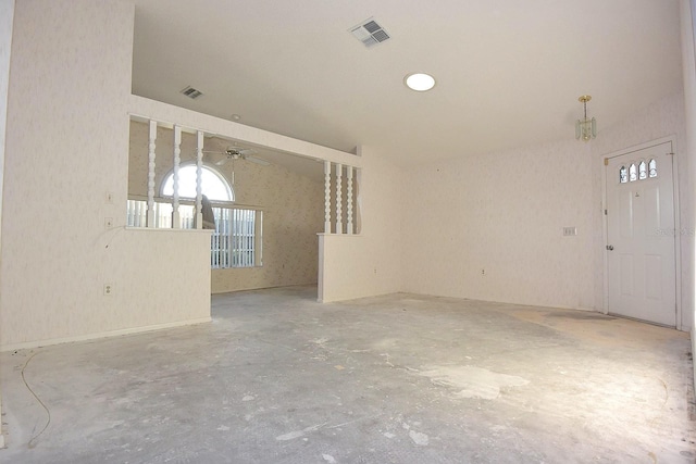 spare room with unfinished concrete flooring, visible vents, and vaulted ceiling