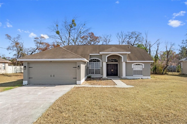 ranch-style house with a garage, a shingled roof, driveway, stucco siding, and a front lawn