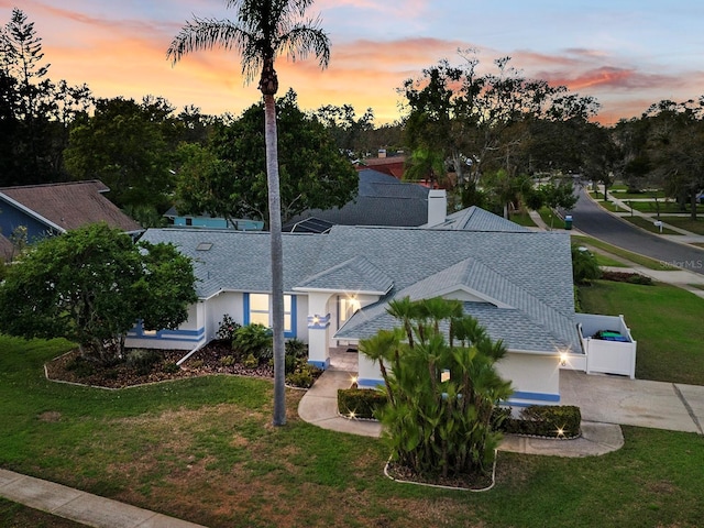 view of front of home featuring a shingled roof and a front lawn