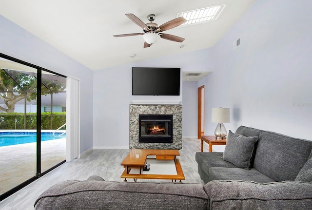 living room featuring visible vents, a ceiling fan, lofted ceiling, wood finished floors, and a fireplace