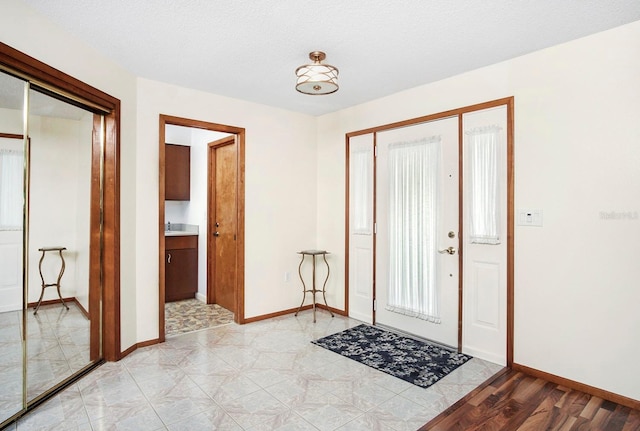 entryway with a textured ceiling and baseboards