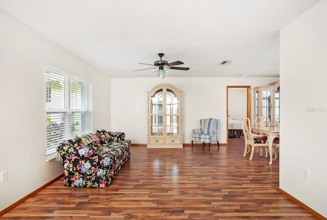 sitting room featuring visible vents, a ceiling fan, a textured ceiling, wood finished floors, and baseboards