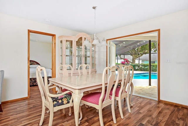 dining room with a chandelier, wood finished floors, and baseboards