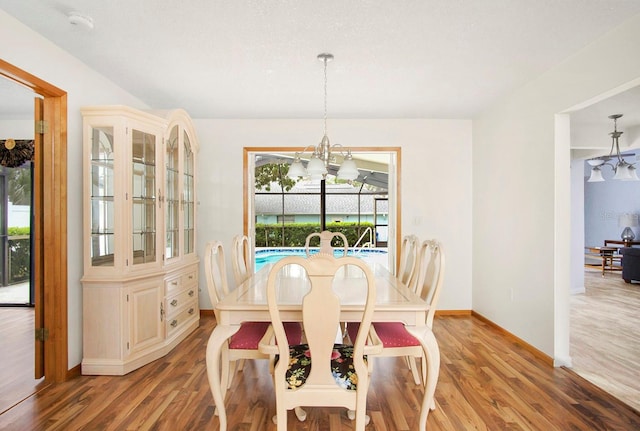 dining room featuring baseboards, a chandelier, and wood finished floors