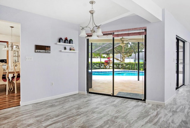 doorway featuring a notable chandelier, baseboards, and wood finished floors