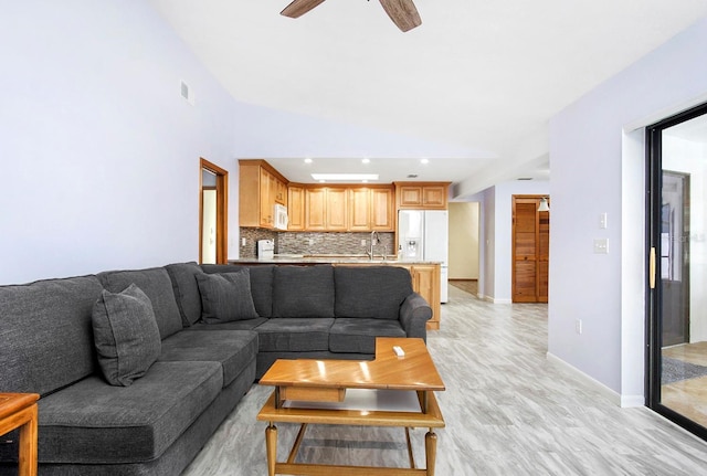 living area featuring light wood-type flooring, ceiling fan, and baseboards