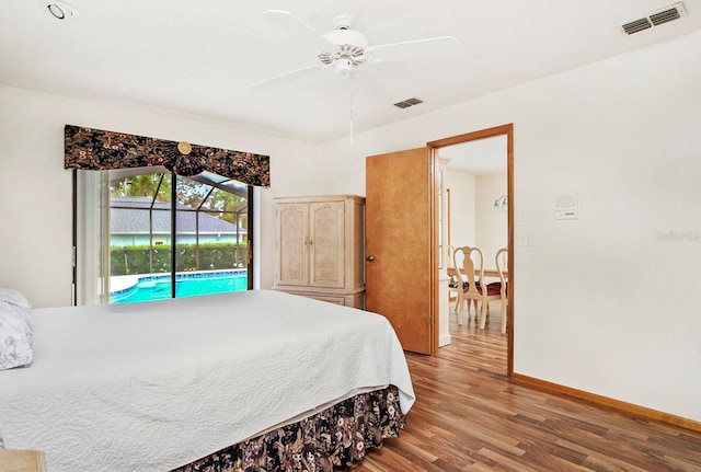 bedroom featuring baseboards, access to outside, visible vents, and wood finished floors