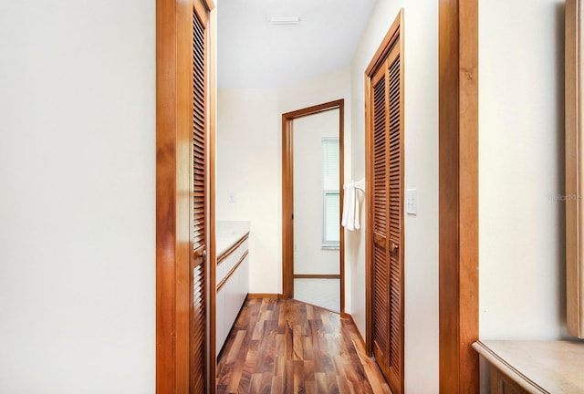 corridor featuring wood finished floors and baseboards