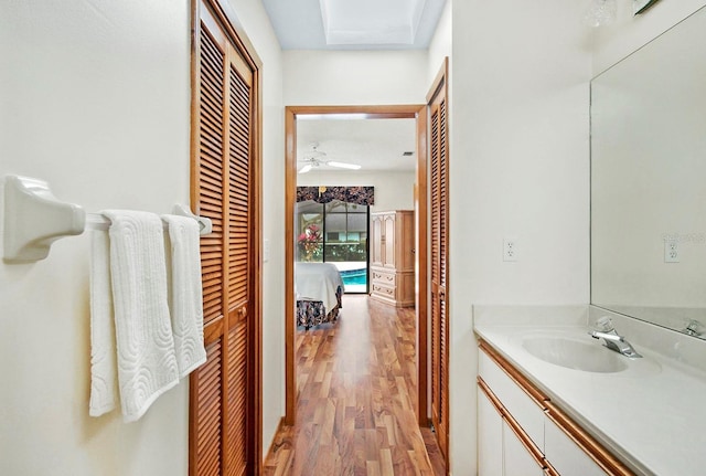 bathroom featuring ceiling fan, wood finished floors, and vanity