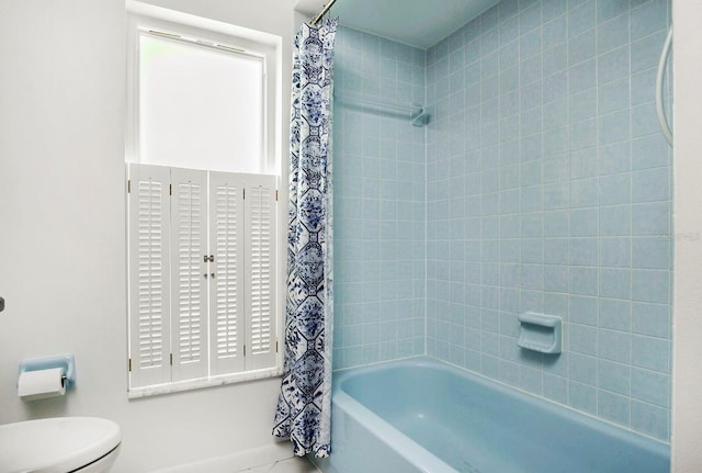 bathroom with toilet and shower / tub combo with curtain