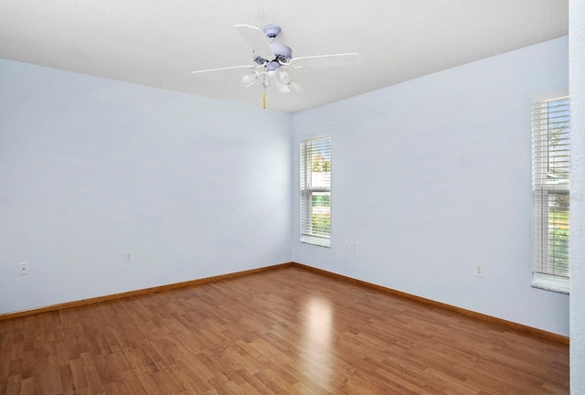 spare room with light wood-style flooring, baseboards, and a ceiling fan