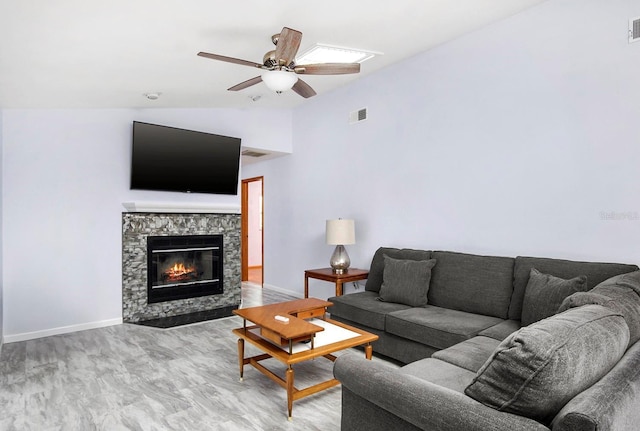 living area with lofted ceiling, a fireplace, visible vents, and baseboards