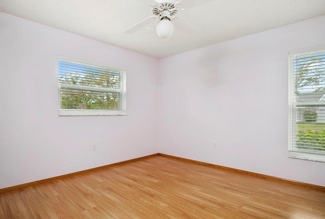 spare room with ceiling fan, light wood finished floors, and baseboards