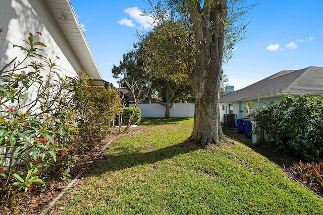 view of yard with central AC unit and fence