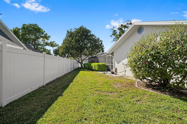 view of yard with a lanai and fence