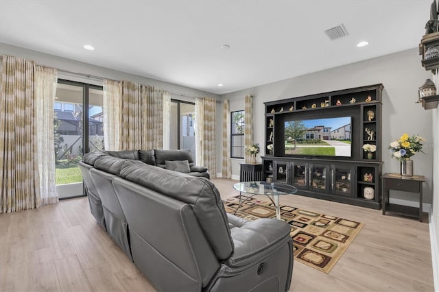 living area with light wood-type flooring, visible vents, baseboards, and recessed lighting