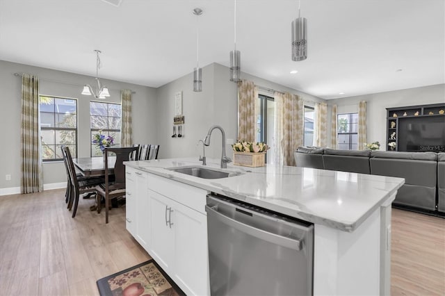 kitchen with a sink, light wood-style floors, a kitchen island with sink, and stainless steel dishwasher