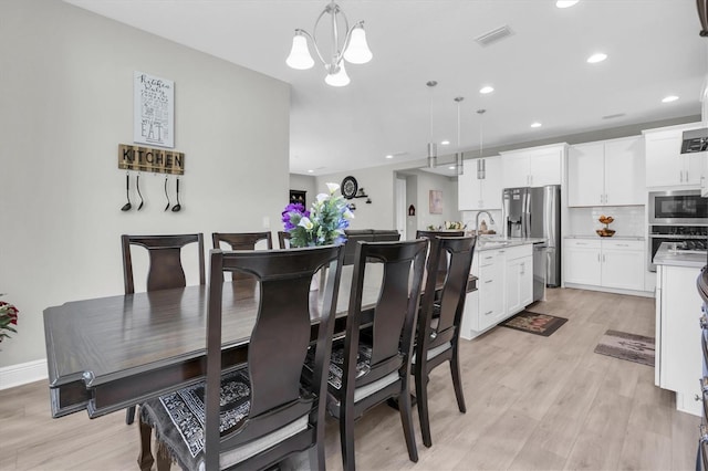 dining room featuring light wood-type flooring, visible vents, a notable chandelier, and recessed lighting