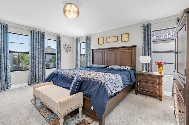 bedroom featuring light carpet and baseboards