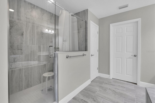 bathroom with visible vents, a shower stall, and baseboards