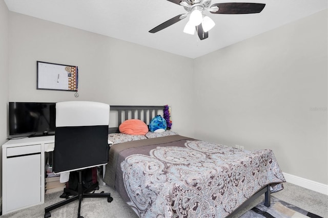 carpeted bedroom with ceiling fan and baseboards