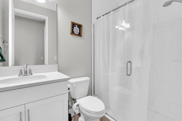 bathroom with toilet, a stall shower, and vanity