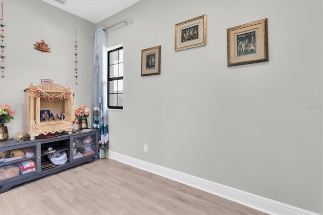 recreation room with baseboards and wood finished floors