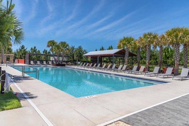 community pool with a gazebo, a patio area, and fence