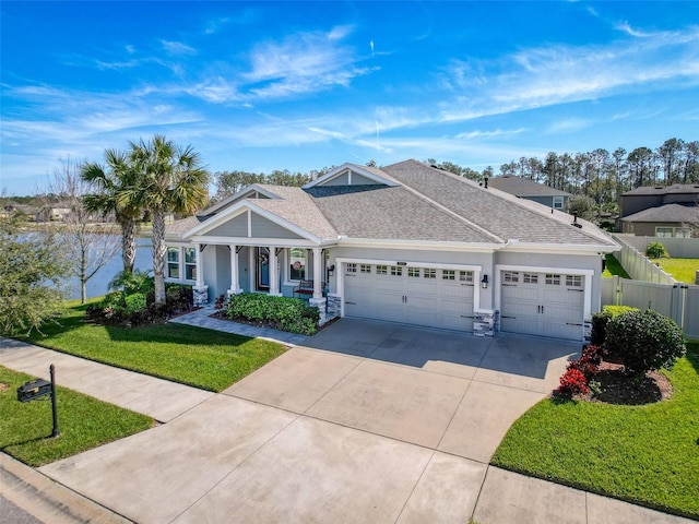 view of front of home featuring a garage, driveway, roof with shingles, fence, and a front yard