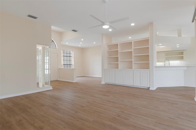 empty room with light wood-type flooring, visible vents, and a ceiling fan