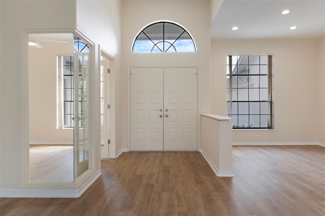 foyer featuring baseboards, wood finished floors, and recessed lighting