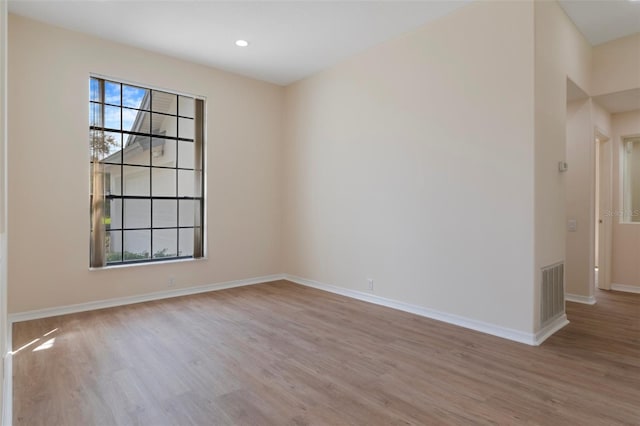 empty room featuring baseboards, visible vents, wood finished floors, and recessed lighting