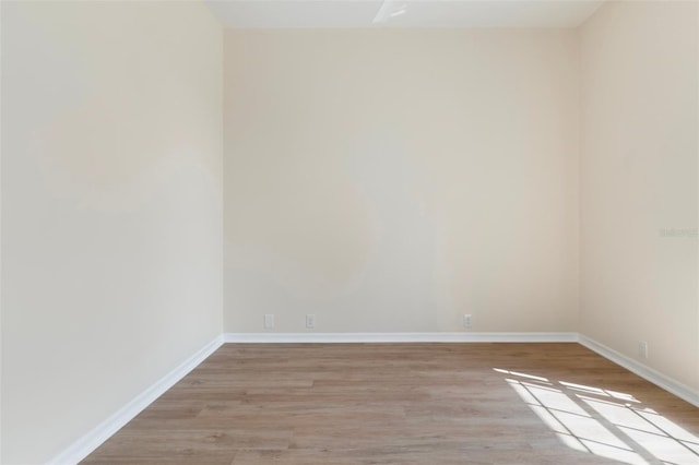 spare room with light wood-type flooring and baseboards