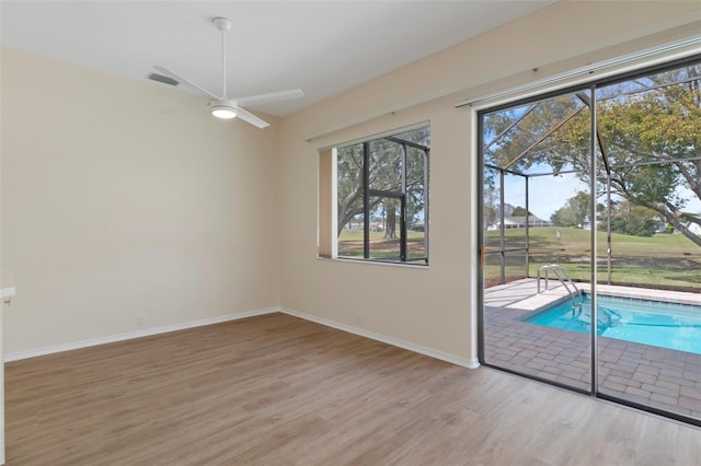 interior space with a ceiling fan, baseboards, and wood finished floors