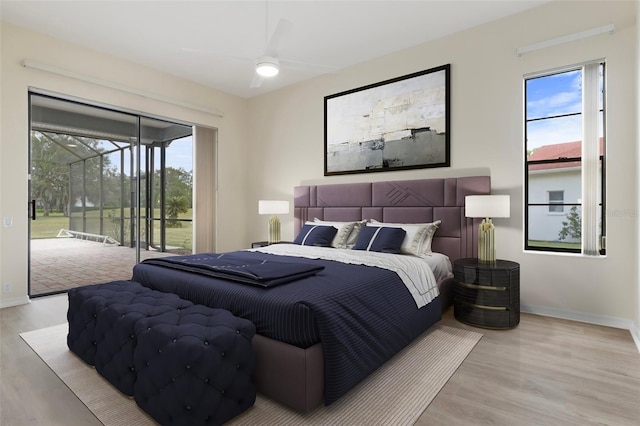 bedroom with access to exterior, multiple windows, baseboards, and wood finished floors