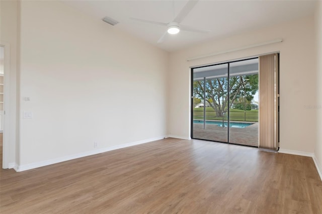 empty room with ceiling fan, light wood finished floors, and baseboards