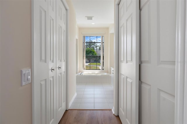 hall featuring tile patterned flooring and visible vents