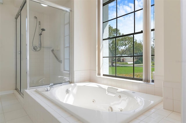 bathroom featuring plenty of natural light, a shower stall, and a tub with jets