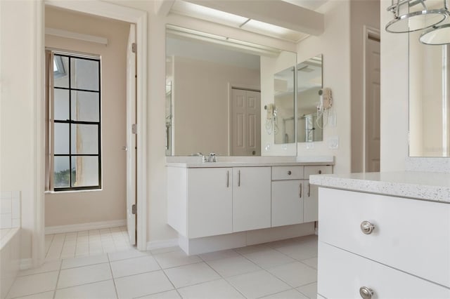 bathroom featuring a wealth of natural light, vanity, baseboards, and tile patterned floors