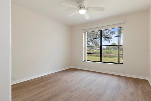 empty room featuring ceiling fan, baseboards, and wood finished floors