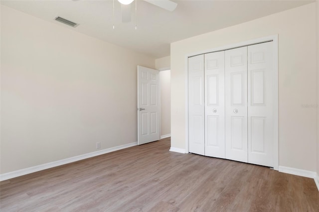 unfurnished bedroom with baseboards, a closet, visible vents, and light wood-style floors