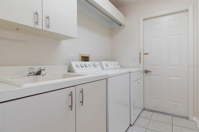 laundry room with a sink, light tile patterned floors, washing machine and dryer, and cabinet space