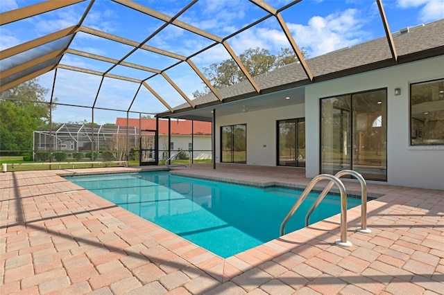 pool featuring glass enclosure and a patio area