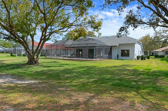 back of property with a lawn and a lanai