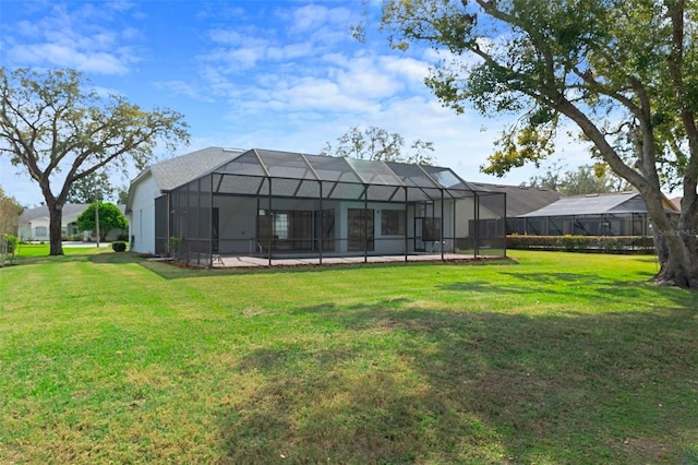 rear view of house featuring a lanai and a yard