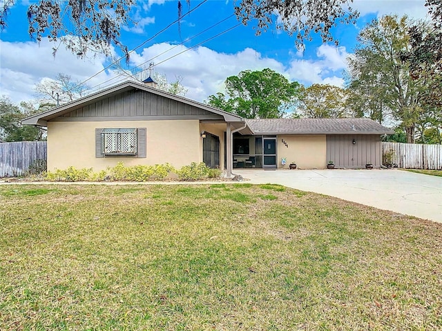 view of front of property featuring a patio area, fence, concrete driveway, and a front yard