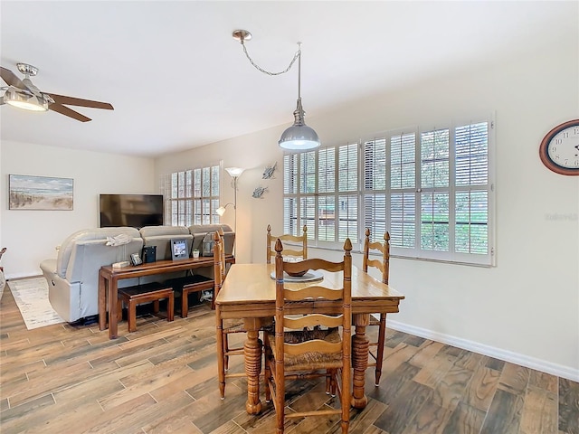 dining area featuring light wood-type flooring, baseboards, and a ceiling fan